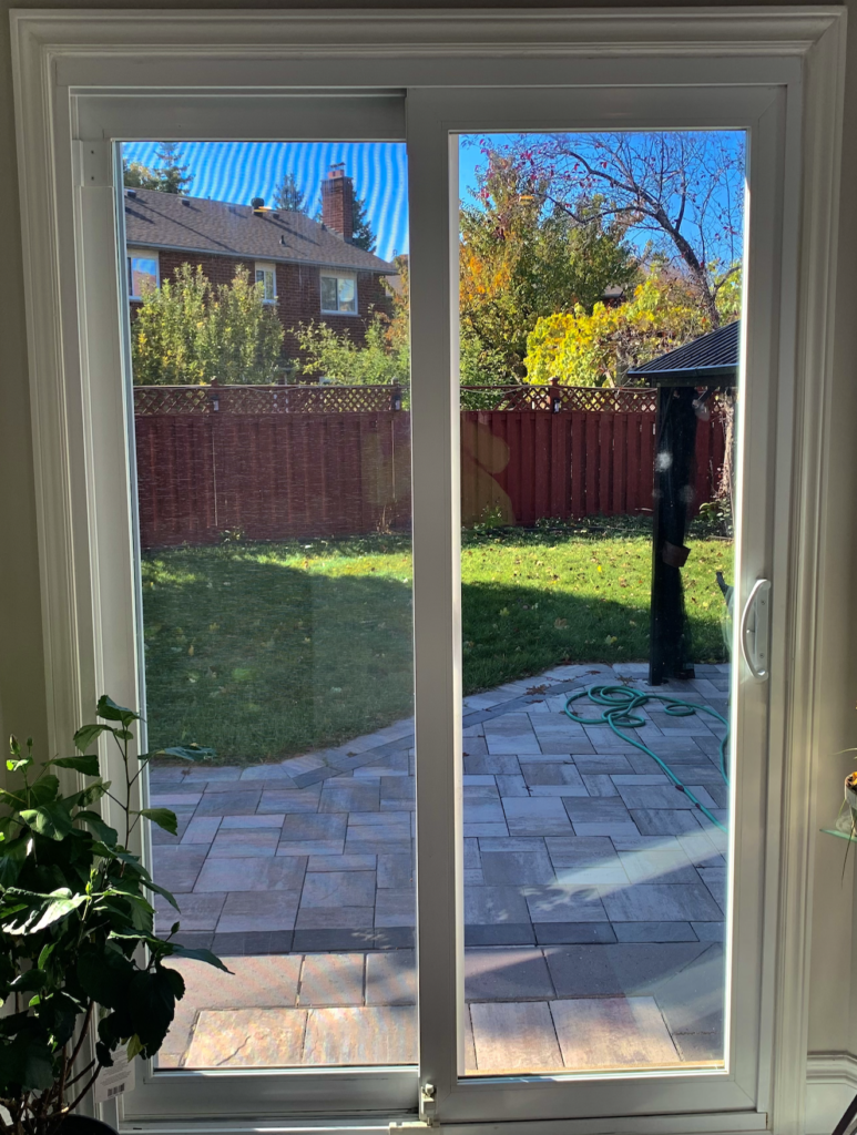 A patio door with a brand new lock and view of the backyard.