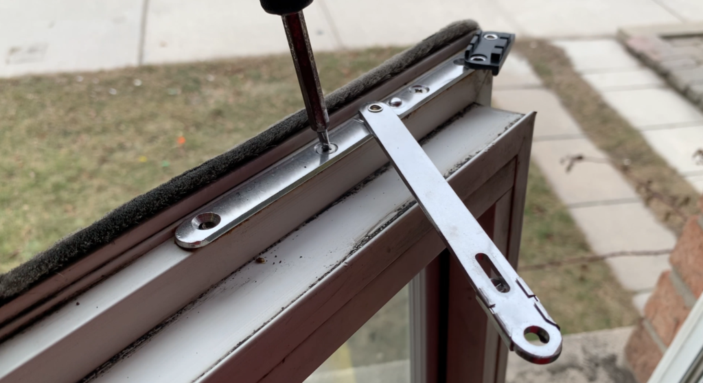 A window being repaired with a screwdriver.