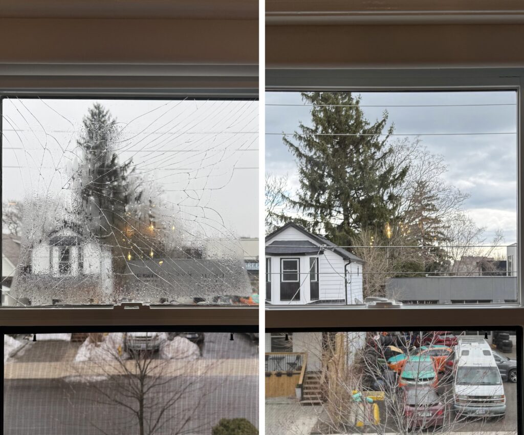 A window with the outside view of trees and houses.