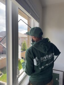 revitalize windows and doors technician replacing foggy glass pane in house.