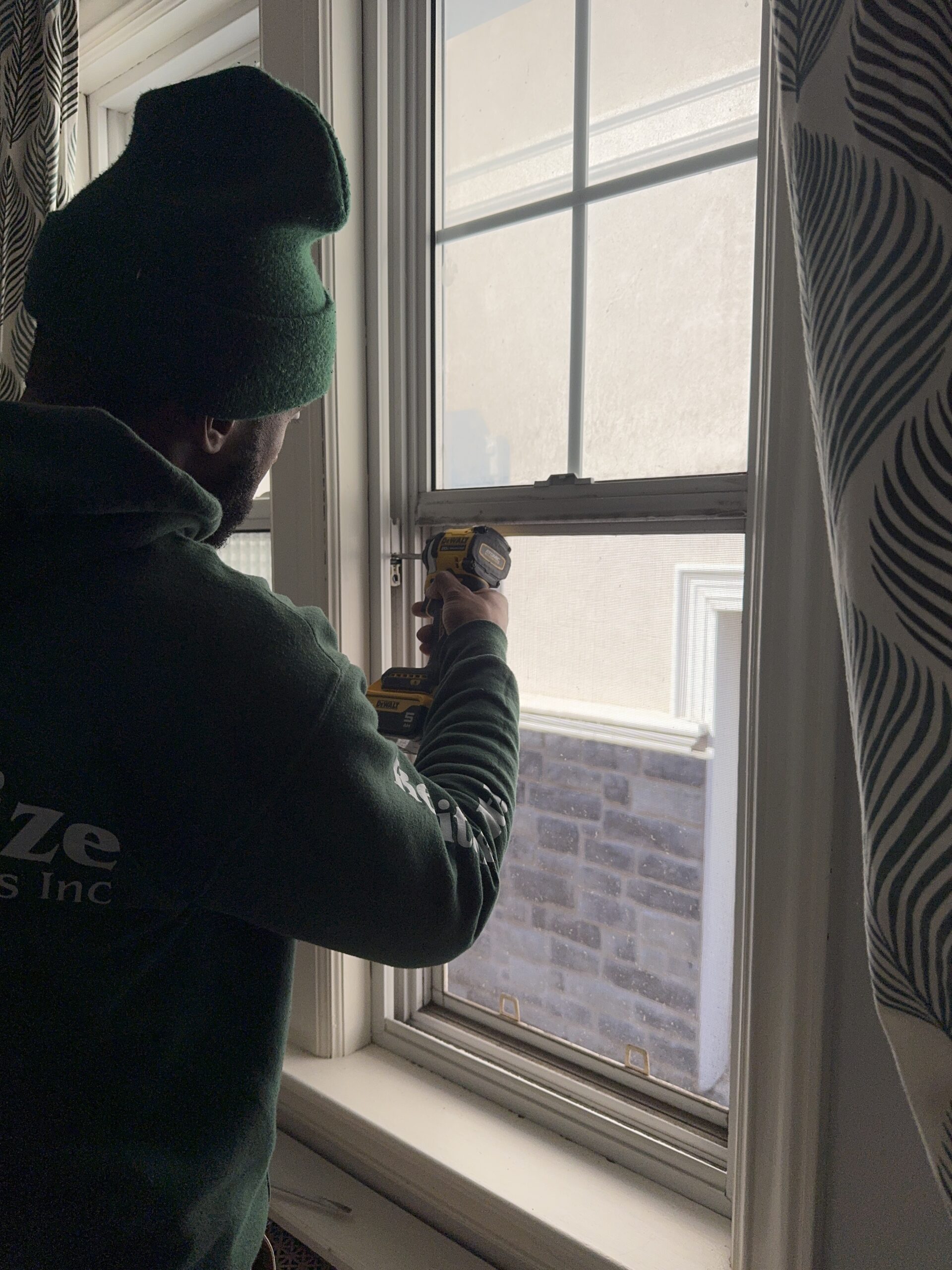 single hung window hardware being replaced by technician.