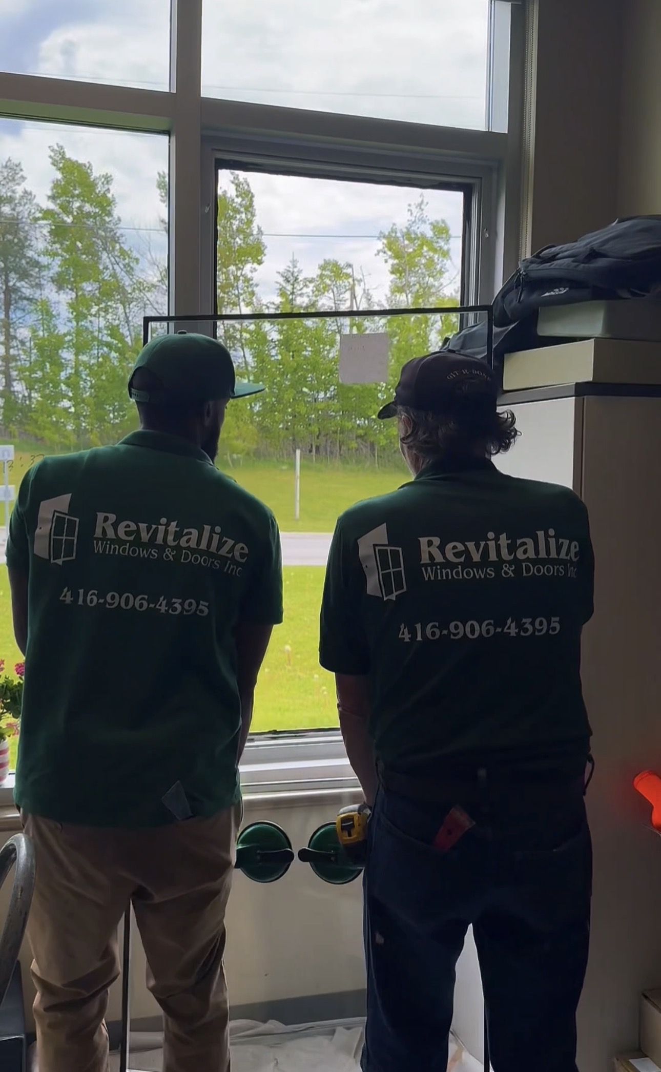 two revitalize windows and doors technicians working on replacing a window pane glass unit.