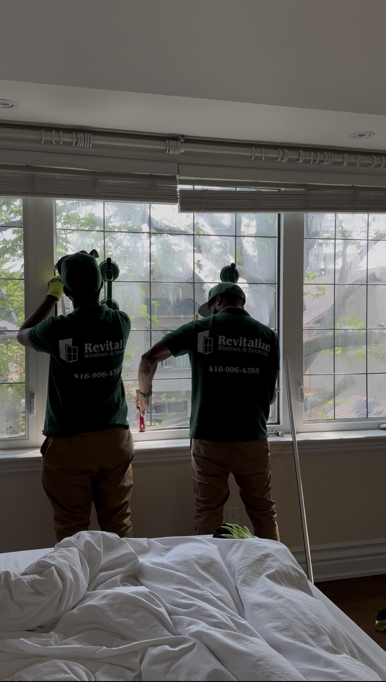 two revitalize windows and doors technicians working on replacing a foggy window pane.