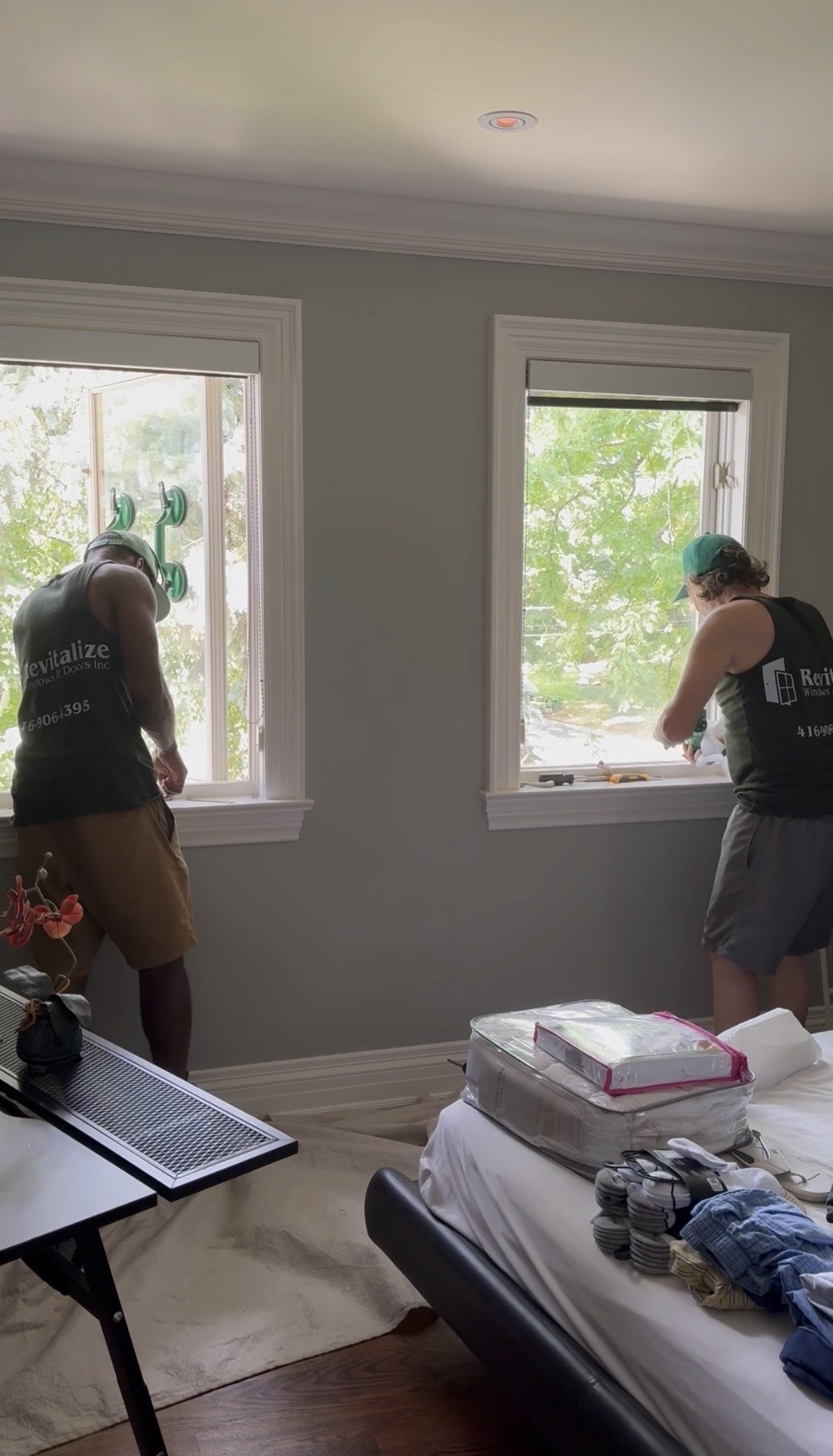 two revitalize windows and doors technicians repairing windows