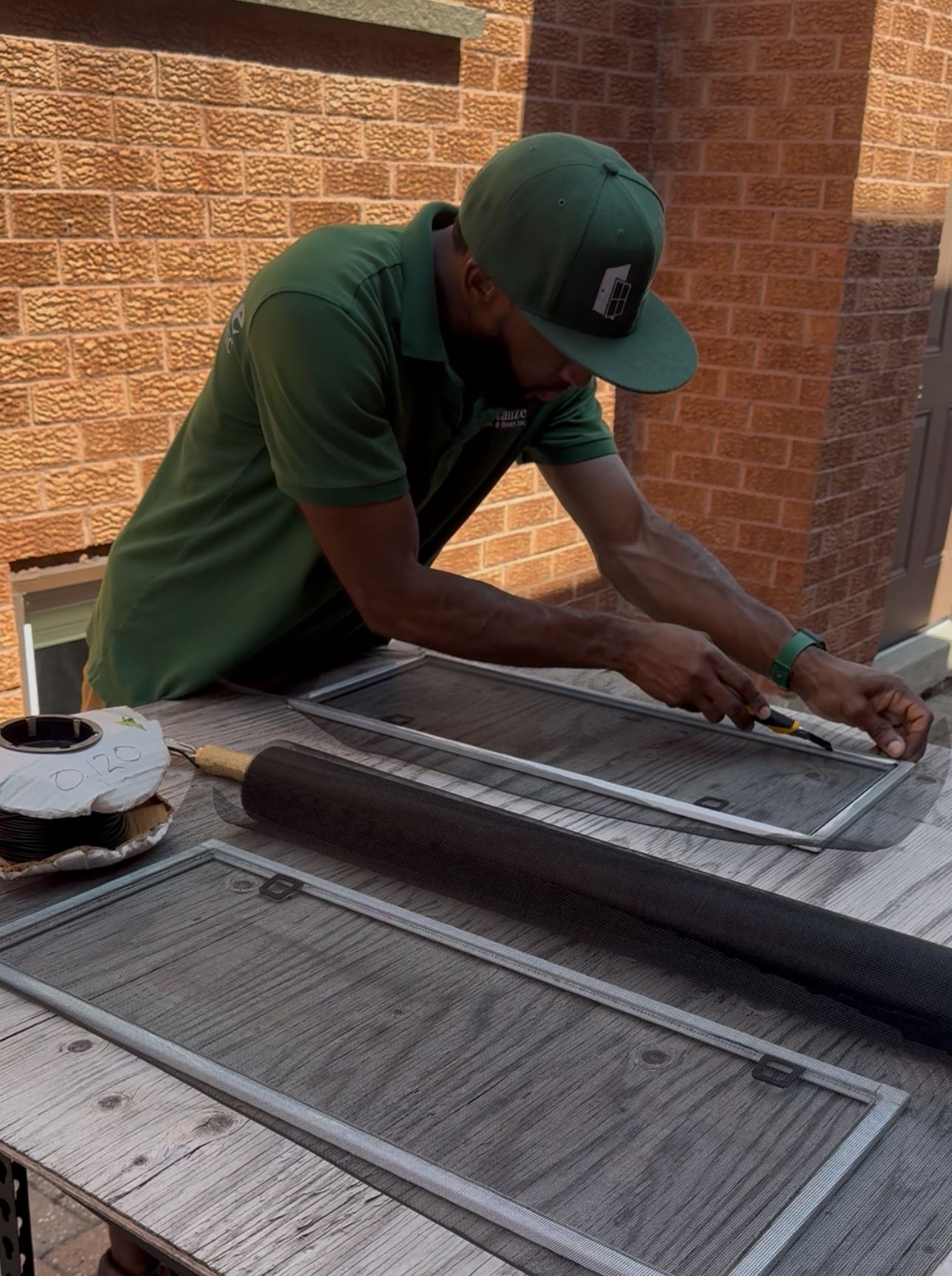window screen mesh being repaired by revitalize windows & doors technician