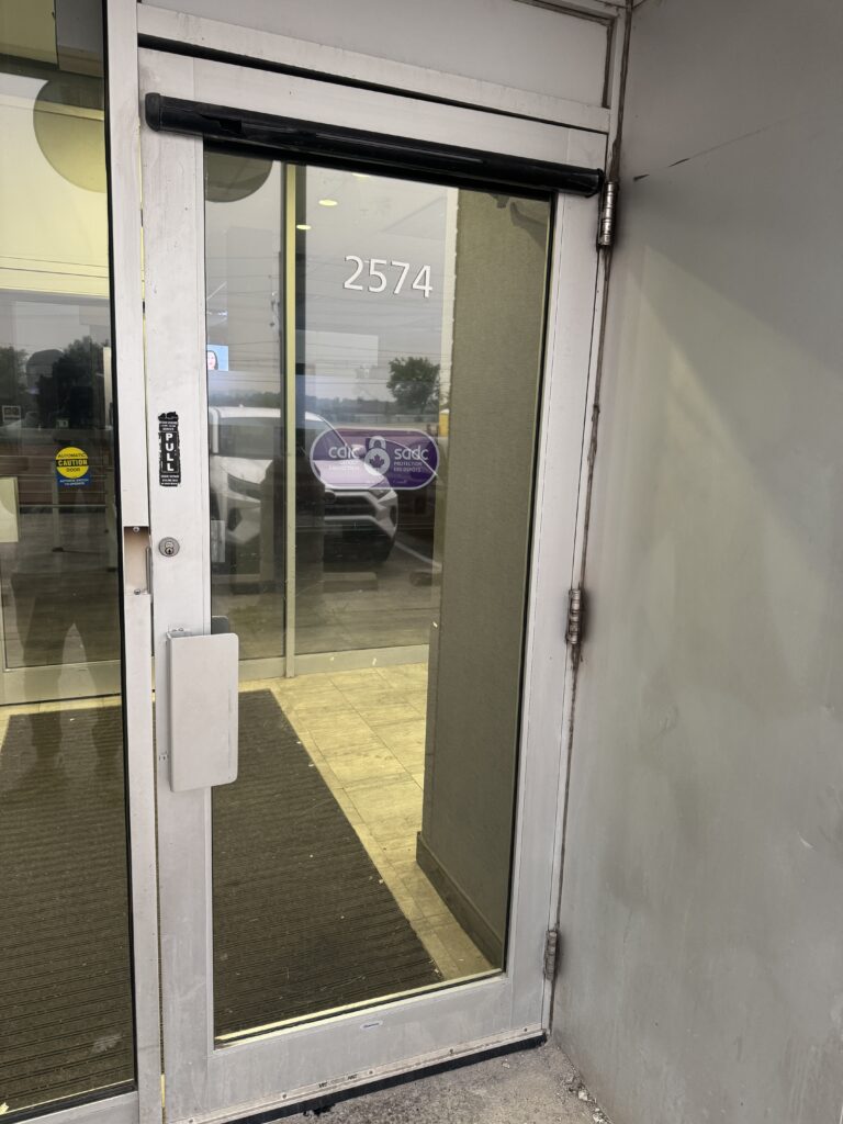 A sagging commercial door with a visible gap at the top, a common hardware wear issue in Toronto.