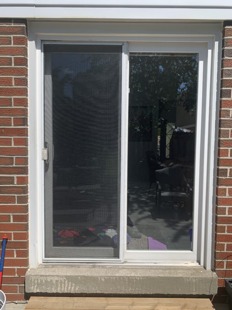 A Revitalize Windows & Doors technician remeshing a sliding screen door in the GTA.
